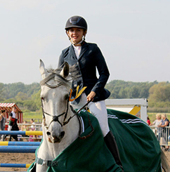 woman jumping a horse over a hurdle